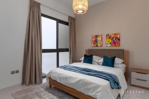 a bedroom with a bed with blue pillows and a window at Boho Inspired Large Luxury Villa in Dubai