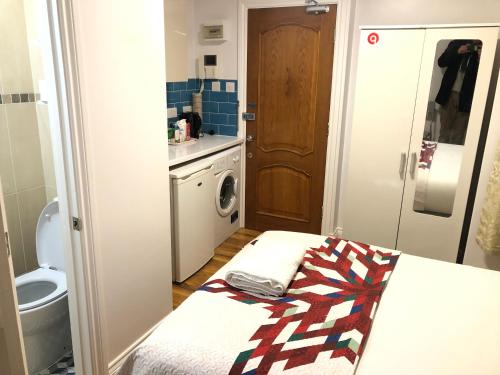 a small bathroom with a bed and a toilet at 36 King Star Hotel in London