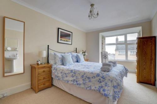 Un dormitorio con una cama y una ventana grande. en Lynton Exmoor Devon stylish comfy Edwardian house, en Lynton