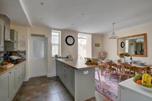 Una cocina con una mesa y un reloj en la pared. en Lynton Exmoor Devon stylish comfy Edwardian house, en Lynton