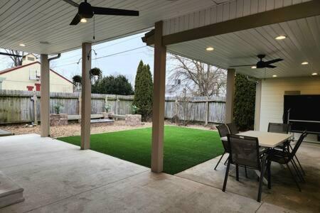 a patio with a table and chairs and a lawn at Large Cozy House Near NexusPark Air Hockey in Columbus