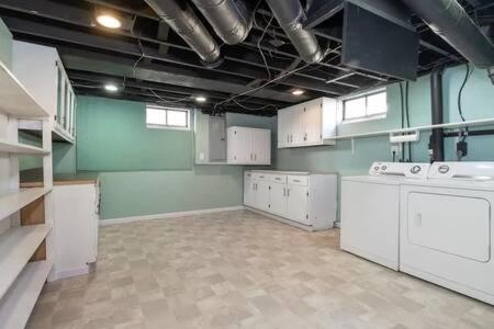 eine große Küche mit weißen Geräten in einem Zimmer in der Unterkunft Large Cozy House Near NexusPark Air Hockey in Columbus