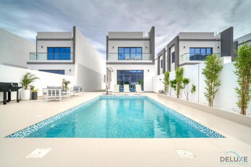 an exterior view of a house with a swimming pool at Beautiful 3BR Villa with Assistant Room Al Dana Island, Fujairah by Deluxe Holiday Homes in Fujairah