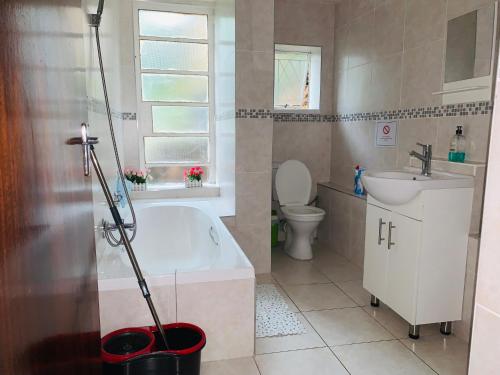 y baño con bañera, aseo y lavamanos. en Naisiae - Lovely 1-bedroom vacation home with pool, en Johannesburgo
