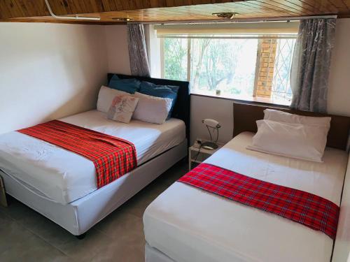 2 camas en una habitación pequeña con ventana en Naisiae - Lovely 1-bedroom vacation home with pool, en Johannesburgo