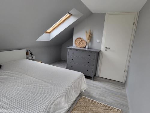 una camera con letto, cassettiera e finestra di Nori&Alex Balaton Apartment a Vonyarcvashegy