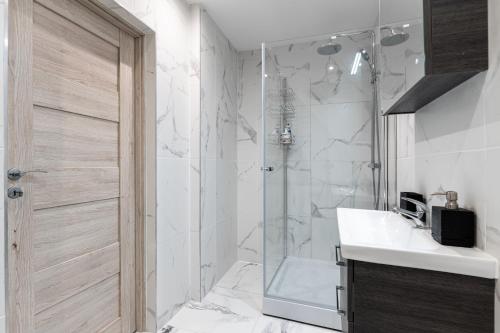 uma casa de banho com um chuveiro, um lavatório e um WC. em Stylish Apartment For up to 4 Guests With WiFi, Free Parking em Vilkaviškis