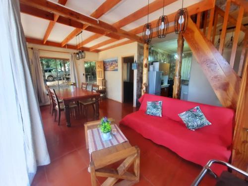 ein Wohnzimmer mit einem roten Sofa und einem Tisch in der Unterkunft Casa comoda in Villarrica