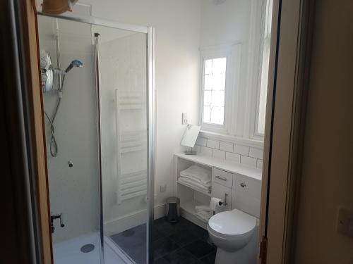 a white bathroom with a shower and a toilet at Hull City Centre Accommodation 1 in Hull
