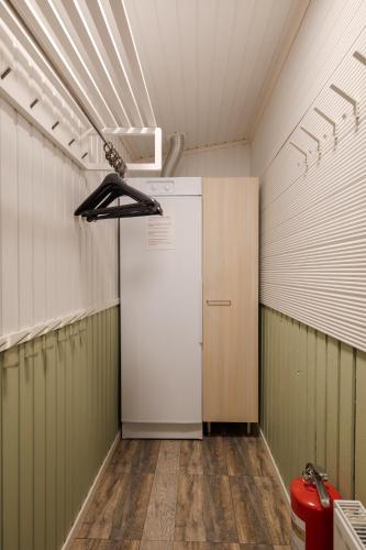 a laundry room with a refrigerator and a closet at Levilehto Apartments in Levi