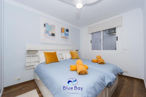 a white bedroom with a blue boy bed with yellow pillows at Atmosphere Luxury Townhouse with Private Pool in La Herradura