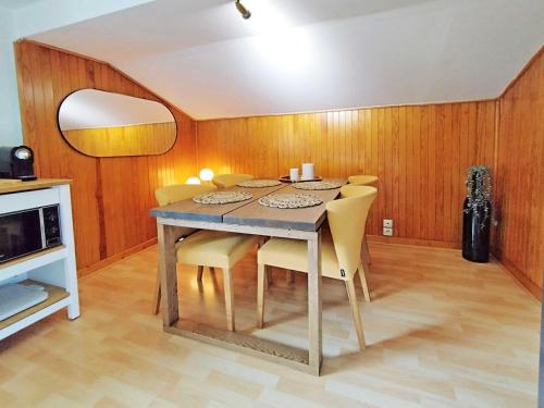 une salle à manger avec une table et des chaises jaunes dans l'établissement Edelweiss 3 Apartment, à Chamonix-Mont-Blanc