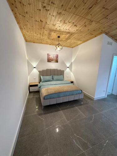 a bedroom with a bed and a wooden ceiling at Qyteza Guest House & Camping in Renc