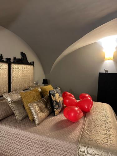 Un dormitorio con una cama con globos rojos. en Home dentro il teatro, en Catania