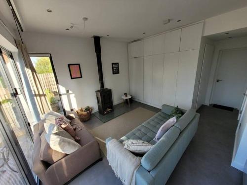 een woonkamer met 2 banken en een tv bij Tiny House in Affluent Suburb-10 min train to City in Kirkintilloch