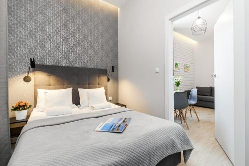 ein Schlafzimmer mit einem Bett mit einem Buch darauf in der Unterkunft Apartamenty Przy Krzywym Domku LTC - Apartments in Sopot