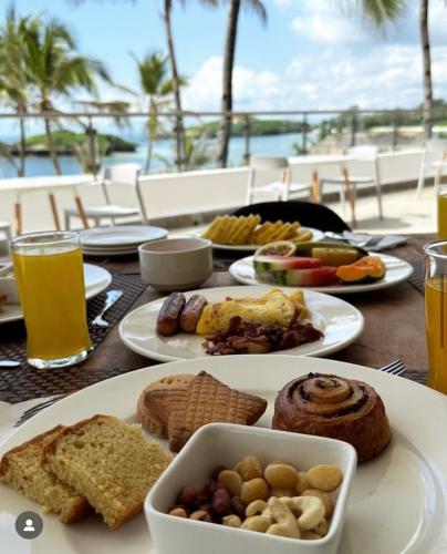 uma mesa com pratos de comida e bebidas sobre ela em Barracuda Inn Resort em Watamu