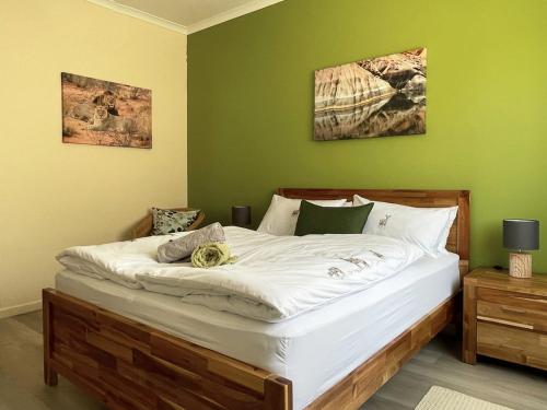1 dormitorio con 1 cama blanca grande y paredes verdes en Anka's Cozy Holiday Home, en Swakopmund