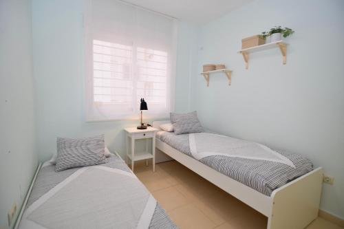 ラ・ヌシアにあるCosta Blanca Apartment La Nuciaの白い部屋(テーブル、窓付)のベッド2台