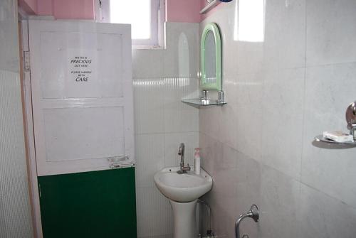a small bathroom with a sink and a toilet at Hotel New Smriya Homestay Inn Darjeeling in Darjeeling