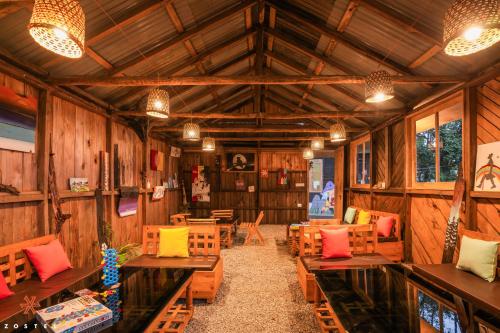 Cette grande chambre est dotée de murs en bois, de tables et de chaises. dans l'établissement Zostel Rinchenpong (Pelling), à Rinchingpong