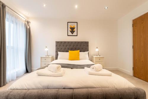a bedroom with a large bed with two yellow pillows at Leeds City Centre Duplex 3 Bedroom 3 Bath stunning Flat with Rooftop Terrace and Parking in Leeds