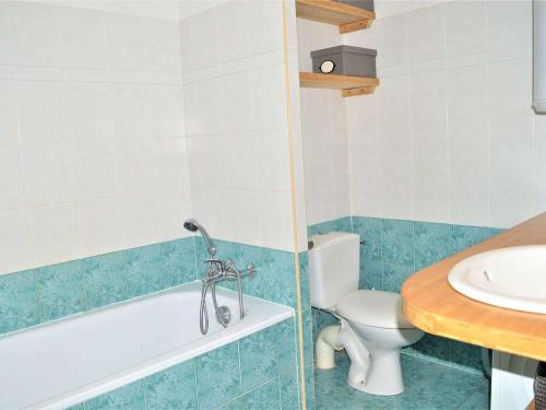 a bathroom with a tub and a toilet and a sink at Appartement Cavalaire-sur-Mer, 3 pièces, 6 personnes - FR-1-226B-32 in Cavalaire-sur-Mer