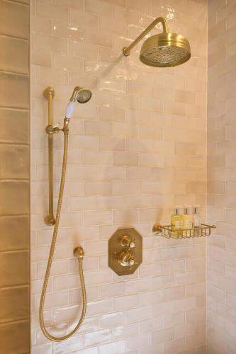 a shower with a shower head in a bathroom at Maison 1896 in Beaune