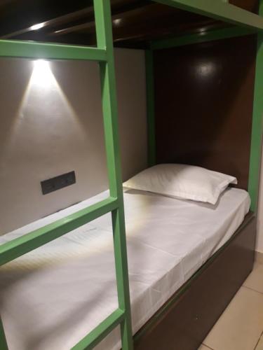 埃爾納古勒姆的住宿－CosyCove，一张绿色双层床,上面有白色枕头