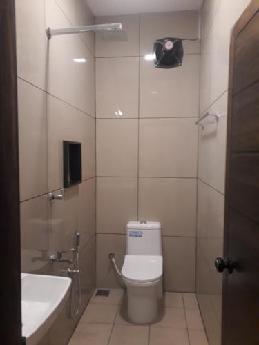 ein Bad mit einem WC, einem Waschbecken und einer Dusche in der Unterkunft CosyCove in Ernakulam