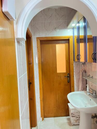 ein Badezimmer mit einem Waschbecken und einer Holztür in der Unterkunft Konfor ve huzurunuz için her şey var klimasız oda in Antalya