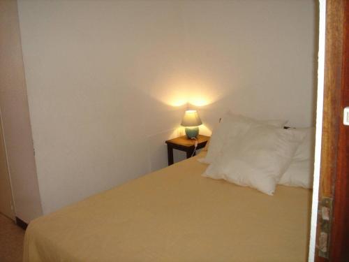 une chambre avec un lit avec une lampe sur une table dans l'établissement Agréable F1 avec balcon à Balaruc-les-Bains, 4 couchages, animaux admis - FR-1-680-10, à Balaruc-les-Bains