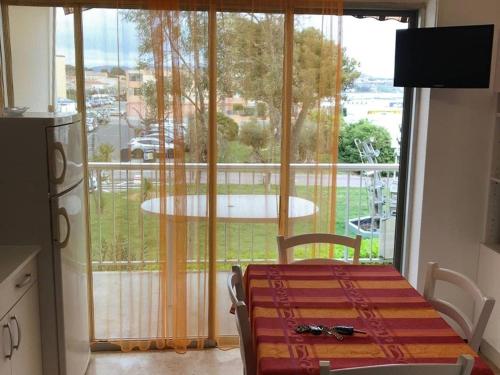Cette chambre dispose d'une table et offre une vue sur un balcon. dans l'établissement Agréable F1 avec balcon à Balaruc-les-Bains, 4 couchages, animaux admis - FR-1-680-10, à Balaruc-les-Bains