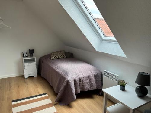 ein Schlafzimmer mit einem Bett im Dachgeschoss mit einem Fenster in der Unterkunft Oustrupgård in Egtved