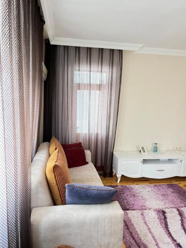 a living room with a couch and a window at Konfor ve huzurunuz için her şey var klimasız oda in Antalya