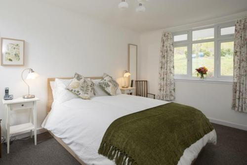 um quarto com uma grande cama branca e uma janela em 2 Bed in Pitlochry CA084 em Struan