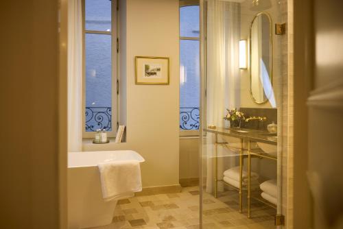 a bathroom with a sink and a mirror and a tub at Maison 1896 in Beaune