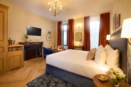 a hotel room with a bed and a fireplace at Maison 1896 in Beaune