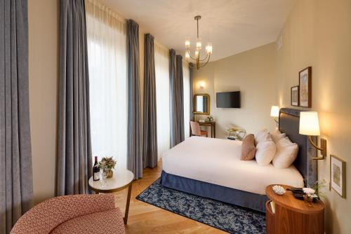 a hotel room with a bed and a chair at Maison 1896 in Beaune