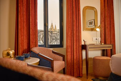 a room with a chair and a window with a view at Maison 1896 in Beaune