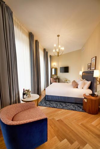 a hotel room with a bed and a chair at Maison 1896 in Beaune
