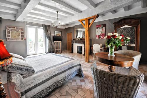 een slaapkamer met een bed, een tafel en een bureau bij Hotel La Roseraie in Chenonceaux