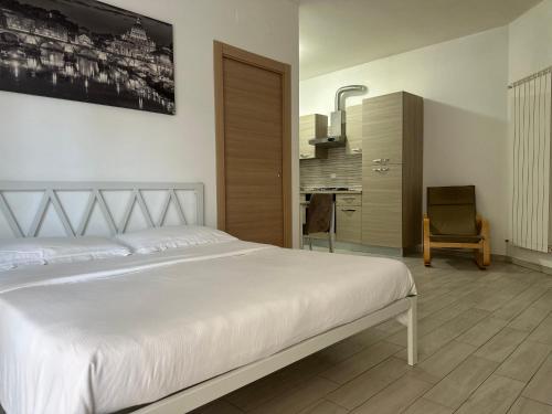 Schlafzimmer mit einem großen weißen Bett und einem Schreibtisch in der Unterkunft Mini suites in Aprilia
