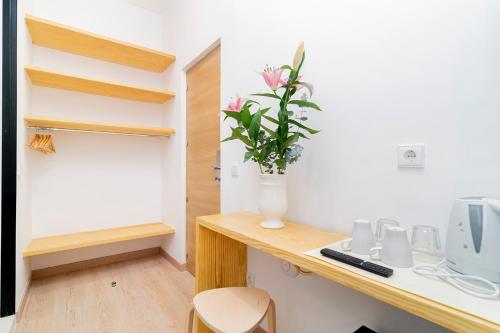 a room with a desk with a vase of flowers on it at OLBLANC Plaza de España by Batuecas in Madrid