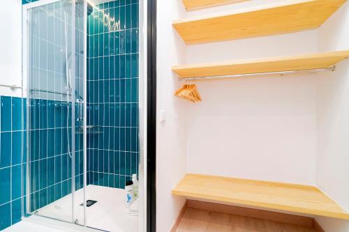 a bathroom with a shower with blue tile at OLBLANC Plaza de España by Batuecas in Madrid