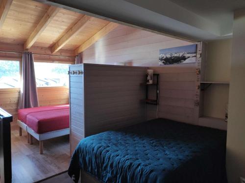une chambre avec un lit dans une petite pièce dans l'établissement Charmant duplex 6 pers avec mezzanine, espace bébé, proche commerces et remontées à l'Alpe d'Huez - FR-1-405-89, à L'Alpe-d'Huez