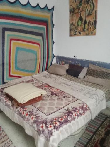 een bed met een dekbed in een kamer bij Venus house15 in Raoued