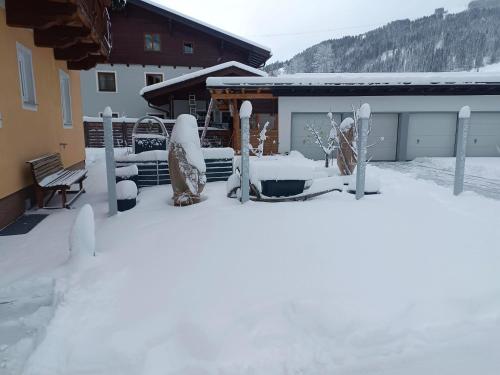 a yard covered in snow in front of a house at Haus Moser in Wagrain