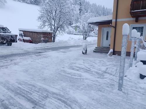 a snow covered street next to a house at Haus Moser in Wagrain