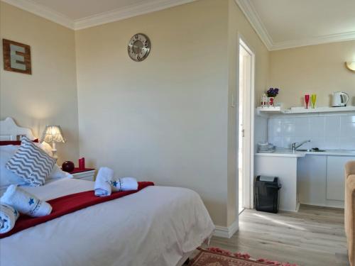 a bedroom with a white bed with towels on it at Summer Tides in Gordonʼs Bay